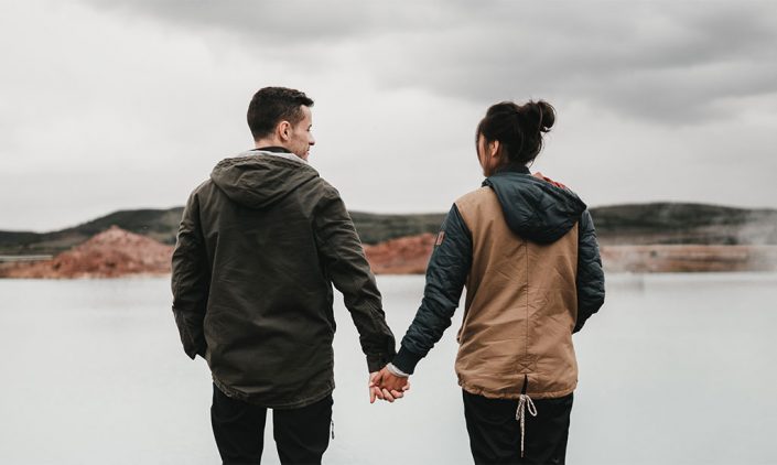 Couple holding hands overlooking a waterway